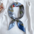 Macro detail of sky blue faux silk square scarf featuring paisley and houndstooth patterns - Blue
