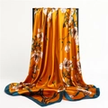 Détail d'un foulard en soie dorée avec motif floral blanc et bordure vert foncé - Bord Jaune Vert Foncé