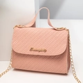 Borsa quadrata rosa intrecciata con tracolla a catena dorata e manico su sfondo minimalista - Rosa