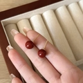 Close-up of elegant red bead earrings with gold posts held by fingers for size display - 10mm / 10mm Red
