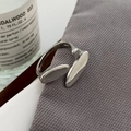 Makroaufnahme eines verstellbaren Silberrings mit asymmetrischem Design auf grauem Stoff - Versilberter offener Ring aus Kupfer