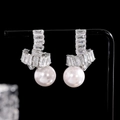 Primer plano de pendientes de perla franceses con diseño de nudo de cristal - Pendientes Colgantes De Perla Y Circón Plateados
