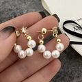 Detailed shot of gold-plated C-shape hoop earrings featuring five white pearls and zircon - Premium Quality Style / White