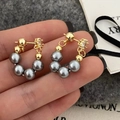 Detail of U-shaped gold earrings with grey pearls and sparkling zircon accents - Premium Quality Style / Gray