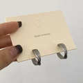 Detalle de pendientes cruzados multicapa con textura en plata mate en tarjeta - Plata Mate