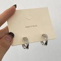Detail van zilveren gedraaide oorringen met dubbel gevlochten metalen ontwerp - Glanzend Zilver