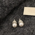 Detail of crown-shaped gold earrings with white pearls and sparkling zircon accents - Crown Pearl Stud Earrings / Gold/White