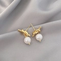 Elegante goldene Knotenohrstecker mit weißen Perlen auf grauem Seidenstoff Hintergrund - Goldener Knoten Weiße Perlenohrstecker