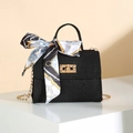 Chic black crossbody bag with decorative silk scarf and gold chain on geometric stand - Black