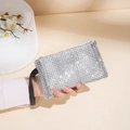 Elegant silver rhinestone clutch bag with a black wrist strap held by a model - Silver
