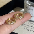 Détail de boucles d'oreilles créoles dorées avec trois trèfles sertis de zircons - Doré