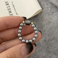 Close-up of a handmade beaded ring with a black cat charm and gray glossy beads - Grey Cat Ring