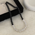 Détail d'un collier de perles noires avec accents argentés et fermoir mousqueton - Collier Pierre Naturelle Noire et Perles d'Argent Irrégulières