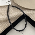 Vue détaillée d'un collier en pierre naturelle noire avec fermoir mousqueton argenté - Collier en Pierre Naturelle 6mm