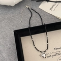 Detail of black faceted bead necklace with polished silver heart pendant on display - Black Faceted Beads / Silver Heart Pendant / Silver Heart Pendant Necklace