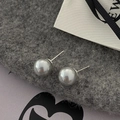 Primer plano de elegantes pendientes de perlas grises con acabado de alto brillo sobre fondo - 10mm / Gris