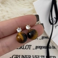 Macro detail of natural tiger eye stone stud earrings with white zircon in gold setting - Gold