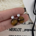 Detailed shot of silver tiger eye stud earrings with sparkling cubic zirconia accents - Silver