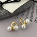 Detailed macro of vintage gold twisted hoop earrings featuring dual elegant white pearls - Gold/White