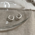 Close-up of chunky silver hoop earrings on a glass plate with linen texture background - Silver Matte Hoop Earrings