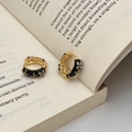 Dettagli di orecchini vintage in oro con smalto nero e pietre di zircone a stella - Orecchini a Cerchio Smalto Nero Fiore