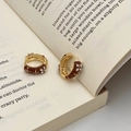 Dettaglio di orecchini vintage con smalto marrone e fiori di zircone su libro - Orecchini a Cerchio Smalto Marrone Fiore