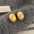 Detail of gold oval stud earrings with matte brushed finish and C LINE PARIS engraving - Gold
