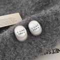 Detail of silver oval earrings with brushed finish and C LINE PARIS engraving on felt - Silver
