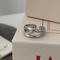 Macro shot of silver polished cross-over minimalist ring on a gift box edge - Crisscross Style / Silver