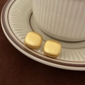 Macro shot of gold square matte brushed earrings on a textured ceramic dish - Gold Brushed Square Style