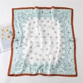 Detail of blue and white paisley silk scarf with orange borders and floral magazine background - Light Blue