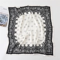 Detail of premium satin square scarf featuring black and white paisley border patterns - Black and White