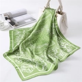 Detail of silk-like paisley and floral printed scarf draped on white leather handbag - 70*70cm / Green