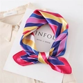 Dettaglio di un foulard di seta quadrato con motivo geometrico a colori vivaci e raso - Stile Geometrico Colorblock / Bordo Rosso Rosa