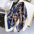 Detail eines Seidenquadrats in Marineblau mit Goldketten und Reitsport-Print auf Marmor - Reiterketten-Druck / Marineblau