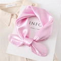 Detail view of a knotted pink silk satin scarf with a smooth finish on a beige shirt - Light Pink