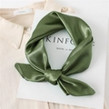Close-up of a dark green satin silk scarf with a glossy finish on a white magazine - Army Green