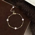Dettaglio del bracciale con perle d'acqua dolce e catena dorata su sfondo in velluto - Bracciale di Perle Tonde (B-137)