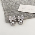 Dettaglio macro di orecchini a fiocco in zircone con perla grigia su maglia - Fiocco d'Argento Perla Grigia