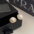 Dettaglio di orecchini a perno con perle vintage e alone di diamanti su scatola nera - Orecchini a Bottone in Perla con Micro Pavè di Zirconia Dorati