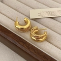 Detail of gold-layered hoop earrings with twisted wire design on a velvet tray - Real Gold Plated Gold