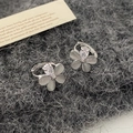 Primo piano di orecchini a fiore in opale occhio di gatto e zircone su maglia scura - Occhio di Gatto Argentato Micro Zircone (Placcato Oro Vero) / Argento