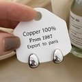 Vue détaillée des boucles d'oreilles argentées en forme de goutte sur tissu beige - Argenté
