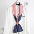 Detail of pink and navy geometric silk scarf styled on a white shirt with flower hanger - Pink Navy Geometric Pattern