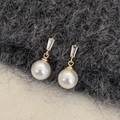 Dettaglio di orecchini di lusso con perla e zircone rettangolare in finitura oro - Oro Perla Bianca