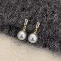 Dettaglio di orecchini con perle grigie, maglie dorate e pietre di zircone rettangolari - Perla grigia color oro