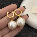 Detailed close-up of vintage 18k gold plated pearl drop earrings held by a hand - Gold Large Pearl Earrings