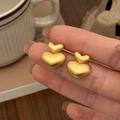 Detail of matte gold double heart earrings with brushed metal texture finish - Brushed Heart Studs / Gold
