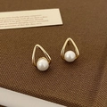 Dettaglio degli orecchini a goccia dorati con eleganti perle bianche incastonate - Oro Perla Bianca