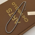 Detailed close-up of dark grey pearl necklace with silver lobster clasp and extension chain - High Luster Grade / 4mm